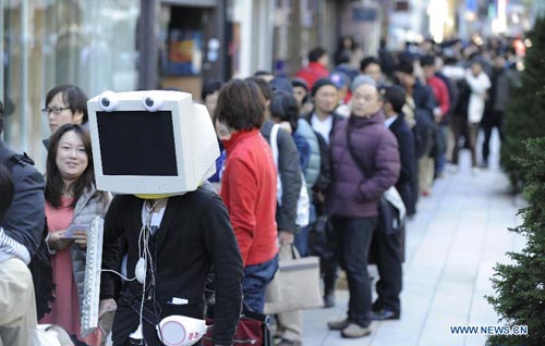 People wait to buy Apple iPad mini in front of the Apple Store Ginza in Tokyo, capital of Japan, on November 2, 2012. Sales of the new iPad mini tablet computer started in Japan on Friday. Photo: Xinhua