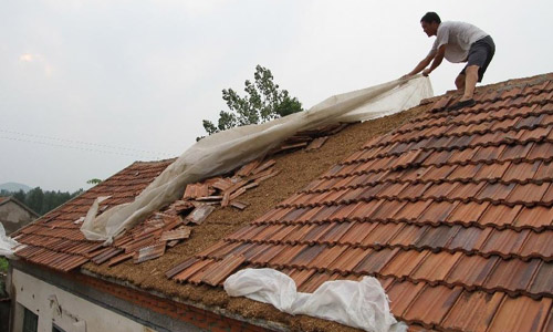 A villager repairs his house which was damaged by cyclone in Hongyuzhuang Village of Tongjing Township in Linyi City, east China's Shangdong Province, July 31, 2012. A cyclone swept the town on Tuesday night, breaking 22 telegraph poles and damaging houses and croplands. Photo: 
Xinhua