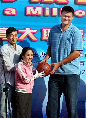 Former NBA player Yao Ming hands a basketball to an athlete delegate Tuesday at the launch of the 