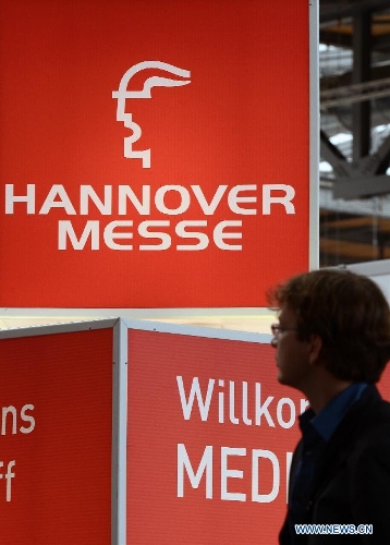 A visitor walks past a poster at the Hannover Industrial Exposition in Hannover, Germany, on April 8, 2013. With the theme of Integrated Industry, Hannover Messe 2013 has attracted the participation of approximately 6,500 exhibitors, making this year's exposition the largest in recent ten years. (Xinhua/Ma Ning) 