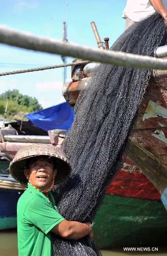 Fisherfolks work on their fishing nets before the annual fishing moratorium starts at Gangbei port in Wanning City, south China's Hainan Province, May 16, 2013. The annual fishing moratorium in Hainan lasts from May 16 to Aug. 1 each year. This year marks the 15th year of fishing moratorium here, and in total 9,007 fishing boats as well as 34,780 fisherfolks are involved. (Xinhua/Shi Manke) 