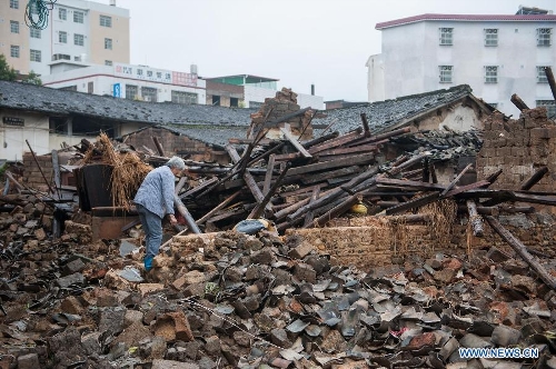 A villager searches in the rubbles of houses destroyed by the rainstorm in Guangfu Town of Jiaoling County, Meizhou City, south China's Guangdong Province, May 22, 2013. Meizhou City was hit by a rainstorm on May 19, which killed one people and destroyed 951 houses, leaving 180, 000 people affected in Jiaoling County. (Xinhua/Mao Siqian) 