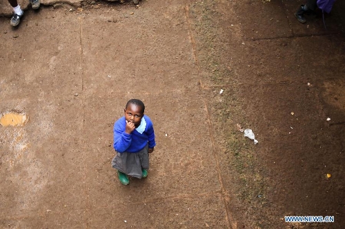 A pupil looks up to the sky at Mcedo Beijing School in Nairobi, capital of Kenya, April 11, 2013. Mcedo Beijing School is located in Mathare slum, one of the largest slums in Kenya and home to about 500,000 residents. The school offered mathematics, English, Swahili, science and some other courses for over 600 students living in three nearby regions. Pupils got free lunch in the school thanks to the United Nations World Food Programme. (Xinhua/Meng Chenguang) 