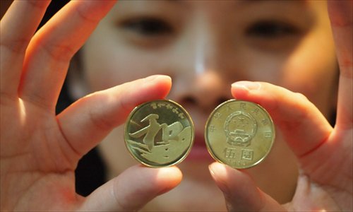 The newly issued 5-yuan ($0.817) coin is displayed. The Central Bank Monday released 50 million 5-yuan coins, which carry the Chinese character he, meaning peace and harmony. The new coins were reportedly sold out in many bank outlets across the country, as many people consider them valuable for collection. Photo: CFP