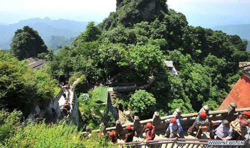 Visitors climb up the Wudang Mountain in central China's Hubei Province July 11, 2012. As the cradle of the Taoist culture, the Wudang Mountain was inscribed on the list of World Cultural Heritages in 1994. The scenery of the mountain attracts tens of thousands of visitors every year. Over 4 million tourists from at home and abroad are expected to visit the site this year. Photo: Xinhua