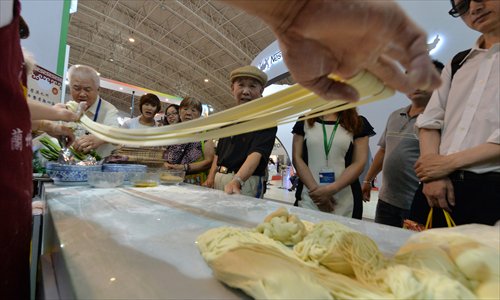 Chinese visitors watch a chef prepare hand-pulled Chinese noodles at the China International Food Safety Technology & Innovations Expo in Beijing on Tuesday. China has recently been hit by a string of food scandals including the sale of rat and fox meat as beef and mutton and selling recycled cooking oil to restaurants. Photo: AFP