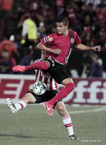 Richard Ruiz (front) of Tijuana's Xolos vies for the ball with Chivas' Juan Orozco during a Liga MX soccer match held in Tijuana, Mexico, on May 3, 2013. (Xinhua/Guillermo Arias) 