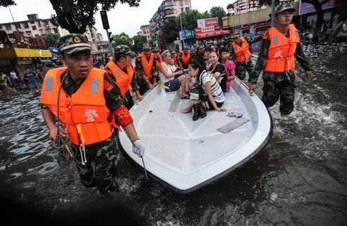 Firefighters transfer citizens by boat in Ningbo, East China's Zhejiang Province, August 9, 2012. As typhoon Haikui landed in Hepu Town of Zhejiang's Xiangshan County early Wednesday, many roads and residential areas were waterlogged after torrential rains in Ningbo. Photo: Xinhua