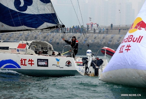 China's Guo Chuan passes a finish buoy on his boat in Qingdao, east China's Shandong Province, April 5, 2013. Guo sailed back home on Friday morning to become the first Chinese to successfully circumnavigate the globe singlehanded. Aboard his Class40 yacht, 48-year-old Guo travelled about 21,600 nautical miles in 138 days before he returned to his hometown of Qingdao, where he set off on November 18 last year. (Xinhua/Li Ziheng) 