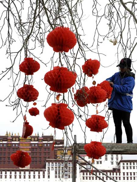 A worker hangs up red lanterns at the square of Potala Palace in Lhasa, capital of southwest China's Tibet Autonomous Region, Feb. 17, 2012. Local people of Tibetan ethnic group were to embrace the upcoming Tibetan New Year, which falls upon Feb. 22 this year. Photo:Xinhua