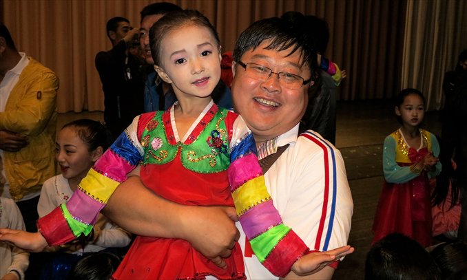 A Chinese tourist poses with a young Korean dancer in Rason, North Korea on June 21, 2012. Photo: CFP