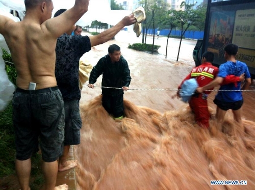 Firefighters establish a warning line in flood in Suining City, southwest China's Sichuan Province, June 30, 2013. Rainstorm-triggered natural disasters have hit nine provincial-level regions since June 29, leaving at least 39 dead and another 13 missing, China's Ministry of Civil Affairs (MCA) said Monday. The National Meteorological Center (NMC) issued a blue alert for rainstorms on Monday, forecasting heavy rain to continue in parts of north and southwest China over the next three days. The NMC also warned of downpours, thunderstorms and hail in south China's coastal Guangdong province and the island province of Hainan, which are bracing for approaching tropical storm Rumbia. (Xinhua/Hu Ming) 