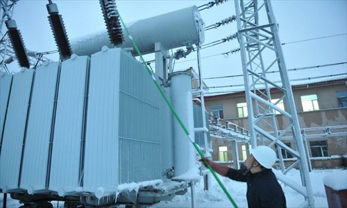 A working staff cleans the snow on a transformer at the Hegang Power Bureau in Hegang, northeast China's Heilongjiang Province, November 12, 2012. Heavy snowstorms have cut off regional power and water supplies as well as forced schools and highways to close in northeast China's Heilongjiang and Jilin provinces on Monday. Photo: Xinhua