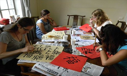 Westerners in a calligraphy class practice drawing the Chinese character fu (good luck). Photo: Global Times