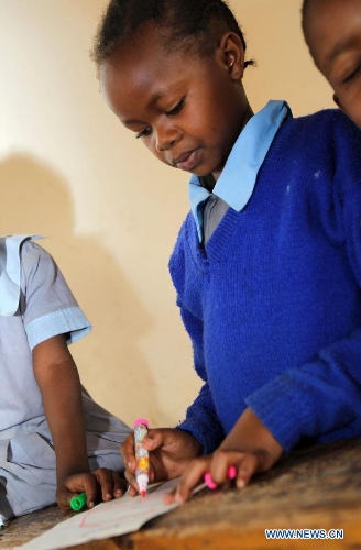 A pupil draws in a classroom at Mcedo Beijing School in Nairobi, capital of Kenya, April 11, 2013. Mcedo Beijing School is located in Mathare slum, one of the largest slums in Kenya and home to about 500,000 residents. The school offered mathematics, English, Swahili, science and some other courses for over 600 students living in three nearby regions. Pupils got free lunch in the school thanks to the United Nations World Food Programme. (Xinhua/Meng Chenguang) 