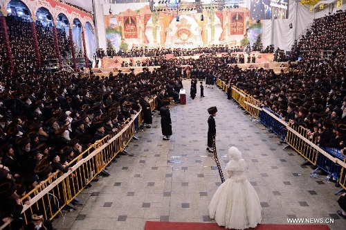 Bride Panett dances with the groom Rabbi Shalom Rokeach, the grandson of the Belz Rabbi Yissachar Dov Rokeach, during their wedding ceremony at the neighbourhood of Kiryat Belz in Jerusalem on May 21, 2013. More than 10,000 Jews participated in the wedding. (Xinhua/Yin Dongxun) 