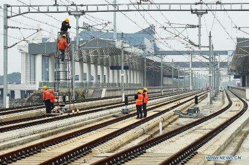  Photo taken on Feb. 21, 2013 shows construction workers working in the completing Shangyu railway station of the Hangzhou-Ningbo high-speed railway in Shangyu, east China's Zhejiang Province. Designed at a top speed of 350km/h, the 150-kilometer Hangzhou-Ningbo high-speed railway linking Hangzhou and Ningbo, two hub cities in Zhejiang, will reduce the travel time to 36 minitues when it is put into operation in July 2013, as expected. (Xinhua/Tan Jin)  