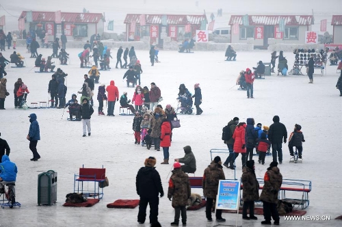 People enjoy the snow and ice activities on the frozen Songhuajiang River in Harbin, capital of northeast China's Heilongjiang Province, Jan. 20, 2013. The temperature rise in Harbin enabled citizens to play with snow and ice in the outdoors. (Xinhua/Wang Kai)  