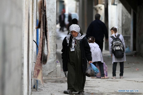 A Palestinian woman walks in the al-Shati refugee camp in Gaza City on March 13, 2013. About 700,000 Palestinians left their homes and settled in refugee camps in the Gaza Strip, the West Bank and neighboring Arab countries. (Xinhua/Yasser Qudih)  