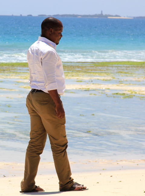 Onesmo Shio, a tour guide in Dar es Salaam, Tanzania, walks on the beach along the coast of Indian Ocean on February 13, 2013. Photo: Zhu Liangliang/GT