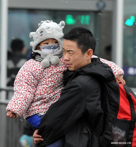 A man carries his daughter at the Beijing West Railway Station in Beijing, capital of China, Feb. 3, 2013. Many children travel with their families during the 40-day Spring Festival travel rush which started on Jan. 26. (Xinhua/Chen Shugen)  