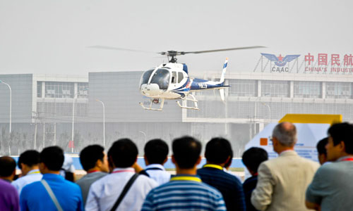 Visitors watch a helicopter show at the China Helicopter Exposition in north China's Tianjin Municipality, September 15, 2011. Tianjin is shaping its aviation and aerospace industry based on the making of aircrafts, large rockets, satellites and space labs. The total output value of the city's aviation and aerospace industry reached 22.77 billion yuan ($3.6 billion) in 2011, growing 33.8 percent on a year-on-year basis. Photo: Xinhua