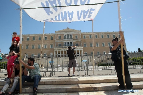 Protesters shout slogans and hold banners in front of the House of Parliament, in Athens, Greece, May 1, 2013. Greece is in the grip of a new 24-hour general strike on Wednesday, as the country's largest unions of public and private sector workers ADEDY and GSEE mark Labor Day with anti-austerity rallies in central Athens and other major cities. (Xinhua/Marios Lolos)  