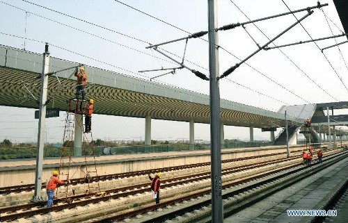  Photo taken on Feb. 21, 2013 shows construction workers working in the completing Shangyu railway station of the Hangzhou-Ningbo high-speed railway in Shangyu, east China's Zhejiang Province. Designed at a top speed of 350km/h, the 150-kilometer Hangzhou-Ningbo high-speed railway linking Hangzhou and Ningbo, two hub cities in Zhejiang, will reduce the travel time to 36 minitues when it is put into operation in July 2013, as expected. (Xinhua/Tan Jin)  