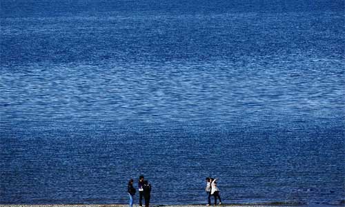 Tourists pose for photos at the Qinghai Lake in northwest China's Qinghai Province, Oct. 3, 2012. Photo: Xinhua