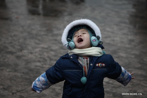  A child feels the snow with open arms at the Beijing train station in Beijing, capital of China, Feb. 3, 2013. Many children travel with their families during the 40-day Spring Festival travel rush which started on Jan. 26. The Spring Festival, which falls on Feb. 10 this year, is traditionally the most important holiday of the Chinese people.Public transportation is expected to accommodate about 3.41 billion travelers nationwide during the holiday, including 225 million railway passengers. (Xinhua/Jin Liwang)