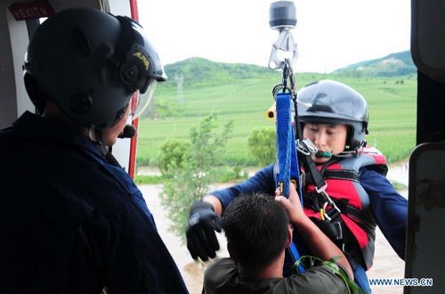 Rescuers transfer a trapped person by helicopter in Liaoyang, Northeast China's Liaoning Province, August 4, 2012. Two helicopters of Beihai Rescue Flying Squad has rescued 24 people trapped by the rain-triggered flood in Liaoyang till 6 pm Saturday. Photo: Xinhua