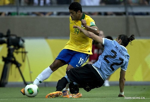 Brazil's Hulk (Top) vies for the ball with Martin Caceres (Bottom) of Uruguay, during the FIFA Confederations Cup Brazil 2013 semifinal match, held at Mineirao Stadium, in Belo Horizonte, Minas Gerais state, Brazil, on June 26, 2013. (Xinhua/Bao Feifei)