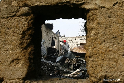 A man looks for reuseable materials at his charred home after a fire hit a residential area in Valenzuela City, the Philippines, Feb. 19, 2013. Around 500 houses were razed in the fire, leaving 2,000 residents homeless. (Xinhua/Rouelle Umali) 