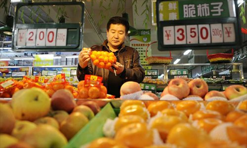 A citizen buys fruit at a market in Yinchuan, capital of northwest China's Ningxia Hui Autonomous Region, December 5, 2012. China's consumer price index (CPI), a main gauge of inflation, grew 2 percent year on year in November, the National Bureau of Statistics announced Sunday. The inflation rate increased from a 33-month low of 1.7 percent in October as food prices increased. Photo:Xinhua