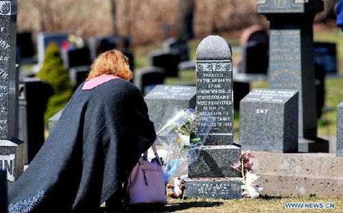 A woman places flowers in front of the tomb of Sidney Leslie Goodwin at the Fairview Lawn Cemetery in Halifax, Canada, April 14, 2012. Sidney Goodwin was a 19-month-old English boy who died during the sinking of the Titanic. For decades he was referred to as 