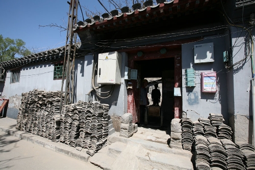 A courtyard in renovation(Photo: CRIENGLISH.com/ Wang Zhi)A Hutong is a traditional alley, characteristic of an old Beijing city. A total of 7000 Hutongs have been built throughout the capital in straight lines under strict construction guildlines. The longest Hutong starts from the Beijing Legation Quarter, Dong Jiao Min Xiang,to the Xijiao Min Xiang, and has a total length of 6.5 kilometers, while the shortest Hutong is One-inch Street at only several meters' long. The narrowest Hutong is only about 0.7 meters wide. Therefore, people carrying even a little bit of extra weight have to hold their breath to pass through it. Formed during the Yuan, Ming and Qing, dynasties thousands of Hutongs surround the supreme Imperial Palace from all directions. They are woven into the fabric of people's daily lives.