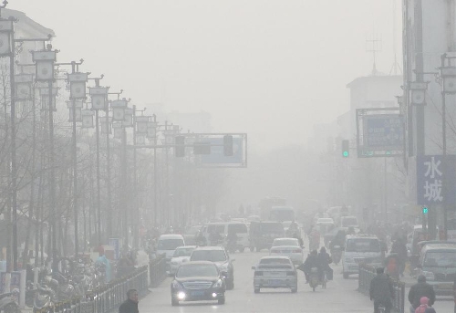 Citizens ride and vehicles run on a fog-shrouded road in Suzhou, east China's Jiangsu Province, Jan. 21, 2013. (Xinhua/Wang Jiankang)  