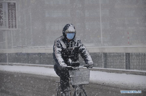 A citizen rides in snow in Jilin City, northeast China's Jilin Province, March 27, 2013. (Xinhua/Wang Mingming) 