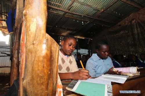 A girl takes notes during a mathematics course at Mcedo Beijing School in Nairobi, capital of Kenya, April 11, 2013. Mcedo Beijing School is located in Mathare slum, one of the largest slums in Kenya and home to about 500,000 residents. The school offered mathematics, English, Swahili, science and some other courses for over 600 students living in three nearby regions. Pupils got free lunch in the school thanks to the United Nations World Food Programme. (Xinhua/Meng Chenguang) 