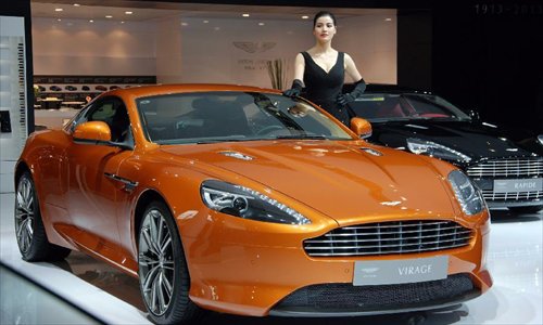 A car model presents an Aston Martin sports car at the 10th China (Guangzhou) International Automobile Exhibition in Guangzhou, capital of south China's Guangdong Province, December 2, 2012. The ten-day auto show, which kicked off on Nov. 23, 2012, closed on Sunday. Photo: Xinhua