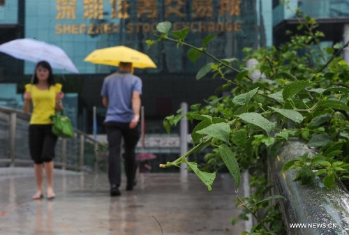 Pedestrians walk amid rain in Shenzhen, south China's Guangdong Province, May 26, 2013. Torrential rain hit most parts of Guangdong Province from Saturday to Sunday. (Xinhua/Mao Siqian)  