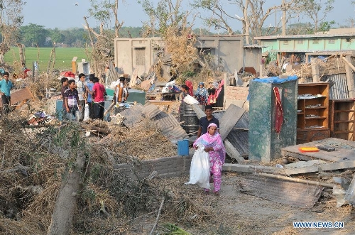 People try to salvage belongings after a tornado in Brahmanbaria district, some 109 km east of the capital of Dhaka, Bangladesh, March 23, 2013. The death toll caused by a devastating tornado in eastern Bangladesh rose to 20 on Saturday, a local TV channel reported. (Xinhua/Shariful Islam)