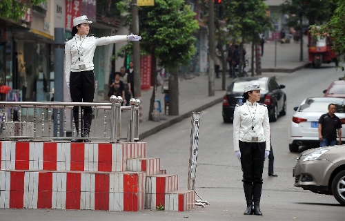 Traffic policewomen are seen on duty in Neijiang City, southwest China's Sichuan Province, April 2, 2013. Founded in April, 2011, the female detachment of local traffic police force includes 2 police officers and 28 auxiliary police officers, with an average age of 23. (Xinhua/Xue Yubin) 