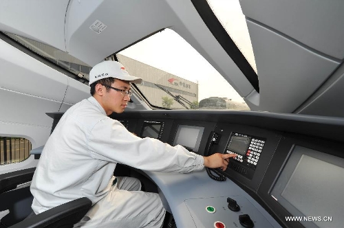 A technicist debugs the intelligent control system of China's first intelligent high-speed test train produced by CSR Qingdao Sifang Co., Ltd in Qingdao, a coastal city in east China's Shandong Province, June 27, 2013. The test train, with China Railway High-Speed (CRH) 380A train as its technical platform, is China's first large transport vehicle applied with the Internet of Things technology and sensor networks technology, through which passengers could enjoy modern information services like e-ticket and Wi-Fi. (Xinhua/Li Ziheng)