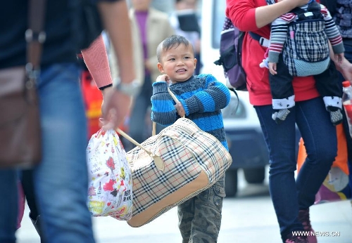 A little boy helps his mother carry a luggage bag at Nanning train station in Nanning, capital of south China's Guangxi Zhuang Autonomous Region, Feb. 3, 2013. Many children travel with their families during the 40-day Spring Festival travel rush which started on Jan. 26. The Spring Festival, which falls on Feb. 10 this year, is traditionally the most important holiday of the Chinese people.Public transportation is expected to accommodate about 3.41 billion travelers nationwide during the holiday, including 225 million railway passengers. (Xinhua/Zhou Hua)