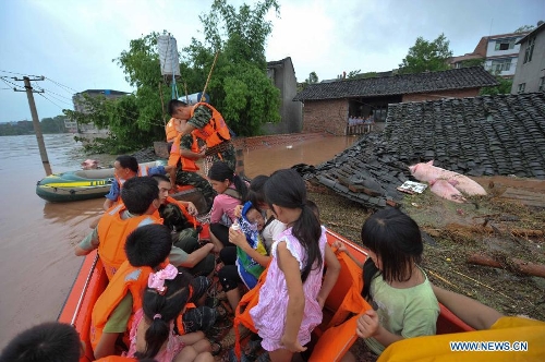 Firemen help evacuate residents at Baizi Town in Tongnan County of Chongqing, southwest China's municipality, July 1, 2013. Rainstorm-triggered natural disasters have hit nine provincial-level regions since June 29, leaving at least 39 dead and another 13 missing, China's Ministry of Civil Affairs (MCA) said Monday. The National Meteorological Center (NMC) issued a blue alert for rainstorms on Monday, forecasting heavy rain to continue in parts of north and southwest China over the next three days. The NMC also warned of downpours, thunderstorms and hail in south China's coastal Guangdong province and the island province of Hainan, which are bracing for approaching tropical storm Rumbia. (Xinhua/Liu Chan)