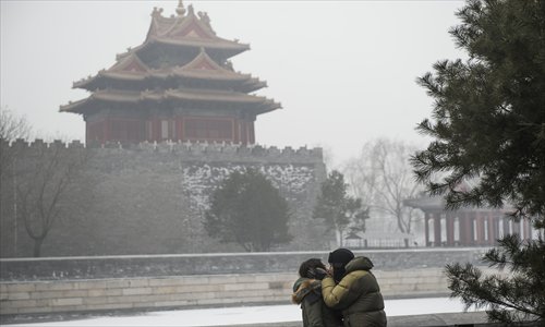 A couple shares a smog-shrouded kiss outside the Palace Museum in Beijing, the capital of China, on January 29, 2013. The National Meteorological Center (NMC) issued a code-blue alert on January 27 as the smoggy weather forecast for the following two days would cut visibility and worsen air pollution in some central and eastern Chinese cities. Photo: Li Hao/GT