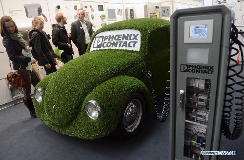 Visitors look at an electric car with a grass shell during the Hannover Industrial Exposition in Hannover, Germany, on April 8, 2013. With the theme of Integrated Industry, Hannover Messe 2013 has attracted the participation of approximately 6,500 exhibitors, making this year's exposition the largest in recent ten years. (Xinhua/Ma Ning) 