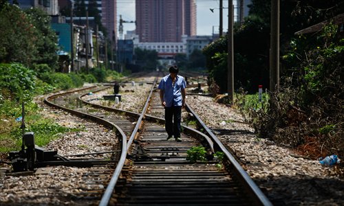 A crossing guard checks the points on railway tracks before a train is due. Photo: Yang Hui/GT