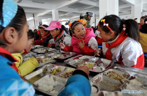 Pupils take their free lunch in the dining hall at No. 1 Primary School of Deqin County in Diqing Tibetan Autonomous Prefecture, southwest China's Yunnan Province, March 12, 2013. A total of 1,260 pupils, most of whom are of the Tibetan ethnic group, study at this school, which was founded in September 2012. Pupils here are offered free meals and lodging. (Xinhua/Lin Yiguang)  